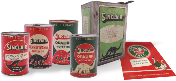 Embalagens de latas com rótulas da Sinclair, todas com o desenho de dinossauro. Há também um panfleto com um dinossauro antropomorfizado na capa